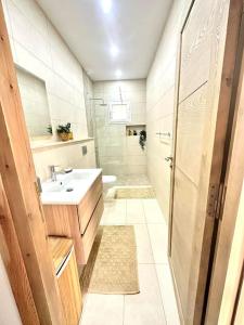 ein Bad mit einem Waschbecken und einem WC in der Unterkunft Villa luxueuse avec piscine in Ḩawmat al Badawīyīn