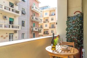 a table on a balcony with a view of a building at Quarzo. Modern Rooms in Cagliari