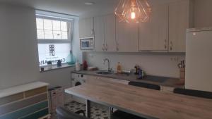 a kitchen with white cabinets and a wooden counter top at Carmen Alta in Tudela