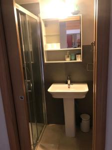 a bathroom with a sink and a shower and a mirror at Ático en la Antigua Casa de Correos in Molina de Aragón