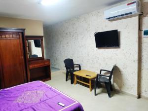 a bedroom with a bed and a table and chairs at Sail Alhasa Tourist Resort-Tafila in At-Tafilah