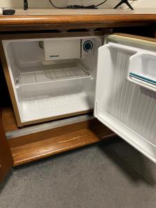 an empty refrigerator with its door open on a counter at Adelaide Inn in Adelaide