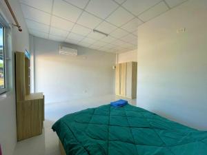 1 dormitorio con 1 cama verde en una habitación en Aviator Club Restaurant & Resort, en Ban Khong Krathin