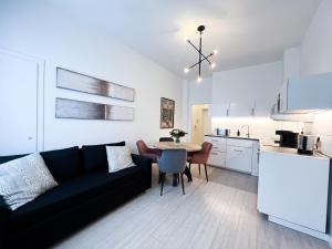 a living room with a black couch and a table at Apartment Düsseldorf City in Düsseldorf