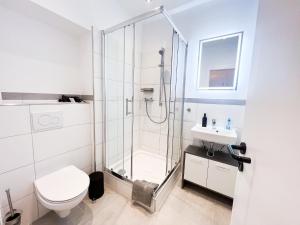 a bathroom with a shower and a toilet and a sink at Apartment Düsseldorf City in Düsseldorf +15 photos