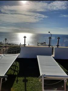 een balkon met 2 banken en uitzicht op de oceaan bij Villa Nicole Vista Mare in Andrano