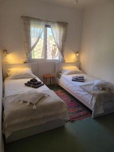 two beds in a bedroom with a window at Seaside Cottage with Garden in Golem