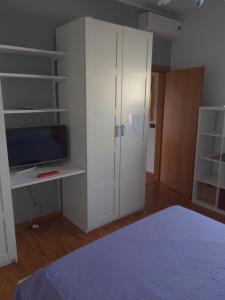 a bedroom with a white cabinet and a tv at Casa da Miki e Ico in Zelo +6 photos