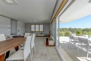 an open living room with a table and chairs at Villa Easy Life by Garda FeWo in Moniga