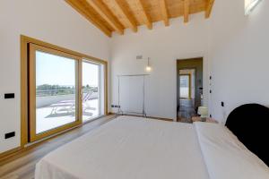 a bedroom with a large bed and a large window at Villa Easy Life by Garda FeWo in Moniga +43 photos