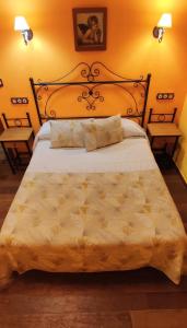 1 dormitorio con 1 cama grande y 2 mesitas de noche en Apartamentos Trinidad, en Alange