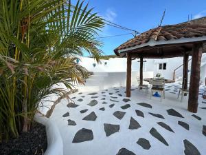伊科德德洛斯維諾斯的住宿－Casa rural con piscina climatizada，露台设有凉亭和桌子。