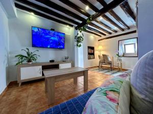 a living room with a couch and a tv on the wall at Casa rural con piscina climatizada in Icod de los Vinos