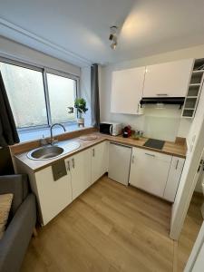 a small kitchen with a sink and a microwave at LE VEGETAL / Nay centre in Nay