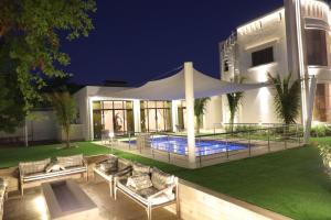 a villa with a swimming pool at night at The home 1 in Wāsiţ