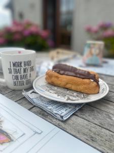 a hot dog on a plate next to a cup of coffee at Oranuisce Thatch Cottage Ballyvaughan in Ballyvaughan