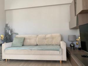 um sofá branco sentado numa sala de estar em Faros Beach sea view apart em Pafos