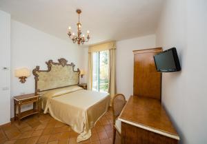 a bedroom with a bed and a flat screen tv at Relais San Giacomo in Maiori