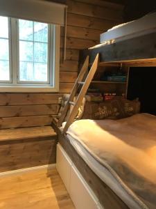 a bedroom with a bunk bed and a window at Remestøylflotti Hyttegrend in Hovden