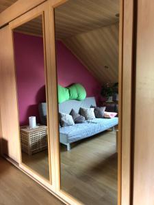 uma sala de estar com um sofá através de uma porta de vidro em Chambre d'hôtes le Vivaldi em Seraing