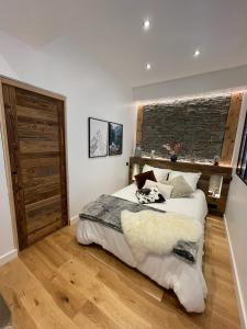 een slaapkamer met een groot bed en een bakstenen muur bij Le Chalet de l'Horloge in Chambéry