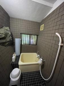 La salle de bains est pourvue d'une baignoire et de toilettes. dans l'établissement えん吉野絶景広がる隠れ家1棟貸切ペットokサウナ室完備, à Yoshino