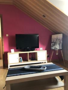 sala de estar con TV y mesa en Chambre d'hôtes le Vivaldi en Seraing