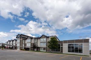 an apartment building with a parking lot in front at Microtel Inn & Suites by Wyndham - Timmins in Timmins