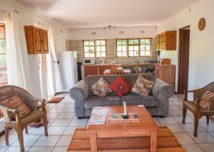 a living room with a couch and a table at Cheerio Trout Fishing & Holiday Resort in Haenertsburg