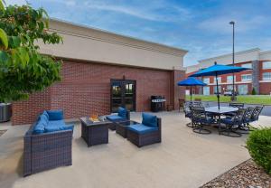 a patio with chairs and tables and umbrellas at Hampton Inn & Suites Madisonville in Madisonville
