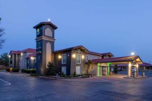 ein Gebäude mit einem Uhrturm auf einem Parkplatz in der Unterkunft La Quinta Inn by Wyndham Kansas City Lenexa in Lenexa