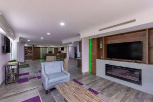 a living room with a fireplace and a flat screen tv at La Quinta Inn by Wyndham Kansas City Lenexa in Lenexa
