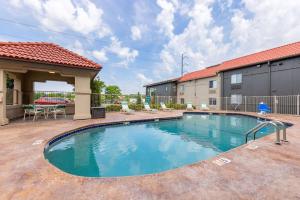 a swimming pool with a patio and a building at La Quinta Inn by Wyndham Kansas City Lenexa in Lenexa