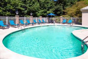 una gran piscina con sillas y sombrilla en Hampton Inn Boston Bedford Burlington, en Billerica