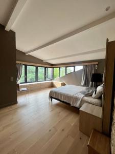 ein großes Schlafzimmer mit einem Bett und einem großen Fenster in der Unterkunft La Demeure du Val (piscine, hammam, spa, salle de sport) in Couzon-au-Mont-dʼOr