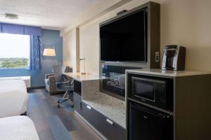 a hotel room with a large television and a bed at Days Hotel by Wyndham North Bergen in North Bergen