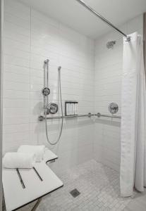 uma casa de banho branca com um chuveiro e uma cortina de chuveiro. em Hyatt Place Newark-Silicon Valley em Newark