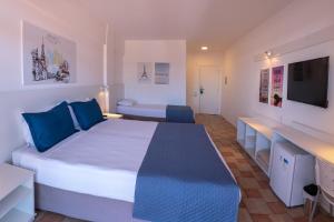 a bedroom with a large bed with blue pillows at Express Floripa Residence in Florianópolis