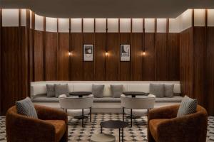 a waiting room with chairs and a couch and tables at Motto By Hilton New York City Times Square in New York