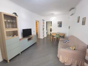 ein Wohnzimmer mit einem Sofa und einem Flachbild-TV in der Unterkunft Da Paolino, tra mare e vino in Viareggio
