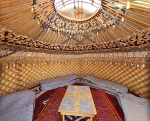 een kamer met een tafel in het midden van een yurt bij Agat Yurt Camp in Kaji-Say