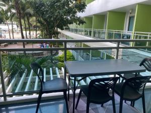 een tafel en stoelen op het balkon van een gebouw bij Azure 1bedroom Beachfront in Manilla