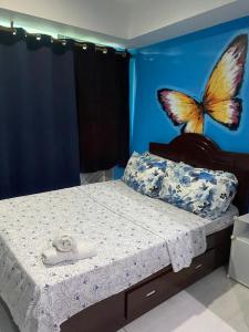 een slaapkamer met een bed met een vlinder aan de muur bij Azure 1bedroom Beachfront in Manilla