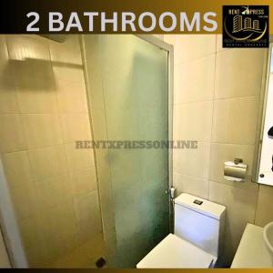 a bathroom with a toilet and a glass shower door at FREE SAUNA & POOL ACCESS PLUS 70 PERCENT LESS PROMO This Month Affordable And Cheapest Deluxe Unit In Manila with Balcony x Near NAIA Airport x Manila Bay x Robinsons Place Ermita x Pgh x Bellagio x UP x Intramuros x Updated 2024 Price Staycation in Manila