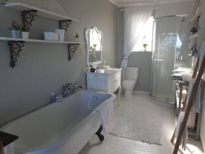 y baño con bañera, aseo y lavamanos. en C the Sea 3bedroom house with 2 queen and 2 single beds max 6sleep 2bathroom walk distance to beach in Glentana Outeniqua Strand with free Wi-Fi and sea view, en Outeniqua Strand