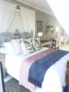 a bedroom with a large white bed with a blue blanket at C the Sea 3bedroom house with 2 queen and 2 single beds max 6sleep 2bathroom walk distance to beach in Glentana Outeniqua Strand with free Wi-Fi and sea view in Outeniqua Strand
