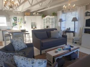 Outeniqua StrandにあるC the Sea 3bedroom house with 2 queen and 2 single beds max 6sleep 2bathroom walk distance to beach in Glentana Outeniqua Strand with free Wi-Fi and sea viewのリビングルーム(ソファ、テーブル付)