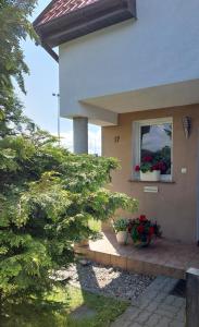 a house with two potted plants in a window at Nella in Darłowo