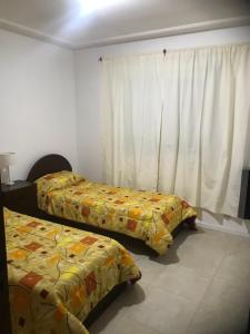 een slaapkamer met 2 bedden en een raam bij Departamentos modernos en Rio Cuarto Yrigoyen in Río Cuarto