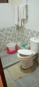 a bathroom with a toilet and towels on the wall at TRANGQUIL APARTMENTS in Kitengela 